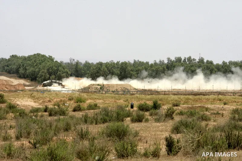 An Israeli tank patrols the area as Israeli bulldozers work along a barbed wire fence that separates Rafah in the southern Gaza Strip and the Israeli border, on June 03, 2015. Israeli troops backed by military vehicles a...