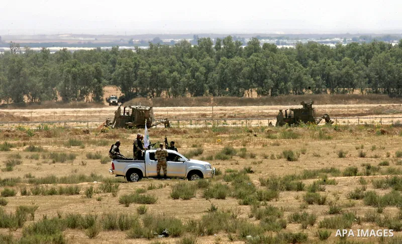 Palestinian militants of the Ezzedine al-Qassam Brigades, Hamas' armed wing, patrol an area 300 meters from the Israeli border with Rafah in the southern Gaza Strip, on June 03, 2015. Israeli troops backed by military ve...