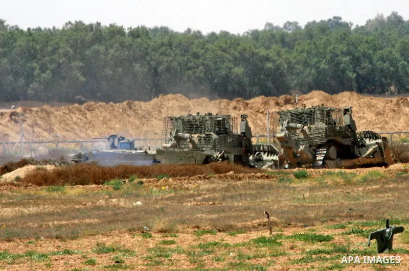 Israeli military bulldozers work along a barbed wire fence that separates Rafah in the southern Gaza Strip and the Israeli border, on June 03, 2015. Israeli troops backed by military vehicles and bulldozers pushed deep i...