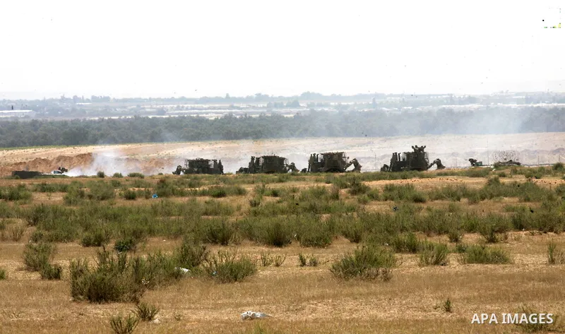 Israeli military bulldozers work along a barbed wire fence that separates Rafah in the southern Gaza Strip and the Israeli border, on June 03, 2015. Israeli troops backed by military vehicles and bulldozers pushed deep i...