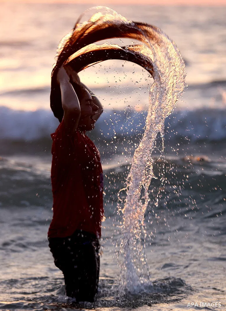 A Palestinian girl swims into the Mediterranean Sea in Gaza City, on June 03, 2015. Photo by Nidal Alwaheidi