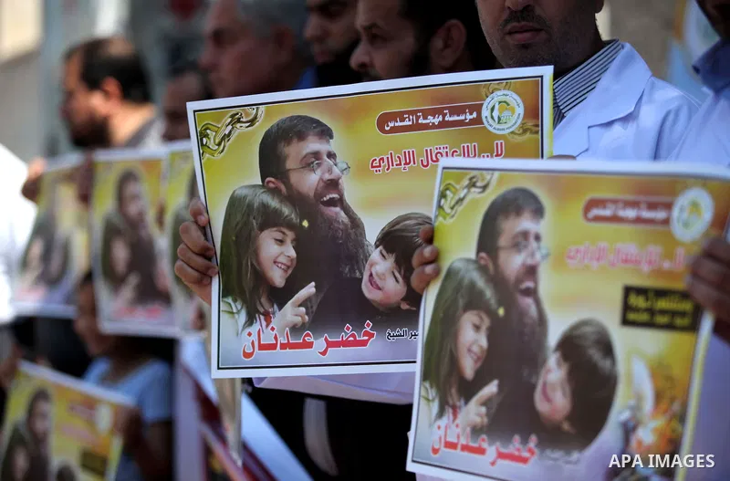 Palestinians holds a picture of Khader Adnan, a senior member of Islamic Jihad jailed in Israel, during a protest calling for the release of Adnan, in front of the red cross office in Gaza city, on June 4, 2015. Photo by...