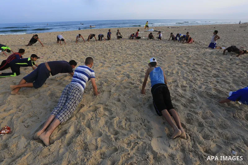 Palestinian boys take part in a training camps of the swimming organized by the Hamas movement into the Mediterranean Sea in Gaza City, on June 6, 2015. Photo by Mohammed Asad