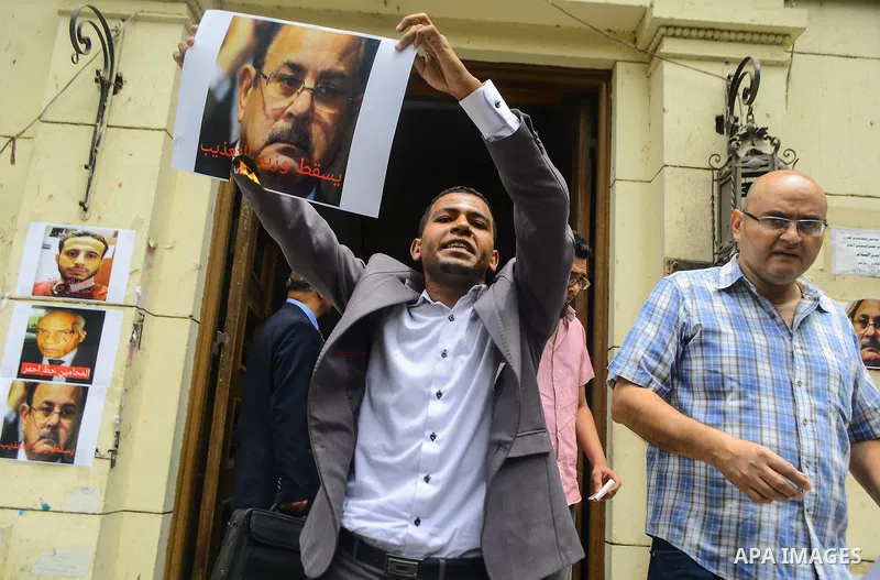 Egyptian lawyers burn pictures of Interior Minister Magdi Abdel Ghaffar, during a protest in front of the syndicate lawyers, Cairo, on June 6, 2015. Photo by Amr Sayed