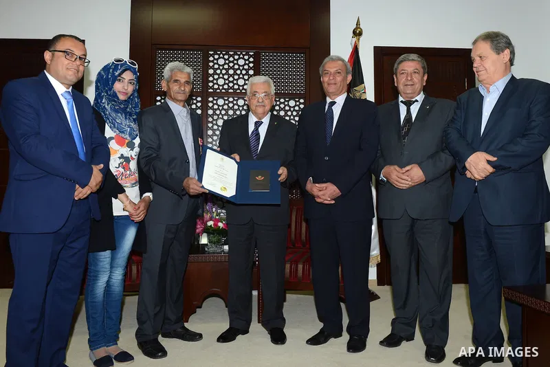 Palestinian President, Mahmoud Abbas (Abu Mazen) honors the Palestinian plastic artist Fathi El-gheben in the West Bank city of Ramallah city on June 6, 2015. Photo by Osama Falah