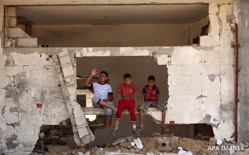 Palestinian children play on the rubble of houses which were destroyed during the 50-day war between Israel and Hamas militants in the summer of 2014, in the Al-Shaaf neighbourhood, on June 06, 2015. Qatar's ambassador M...