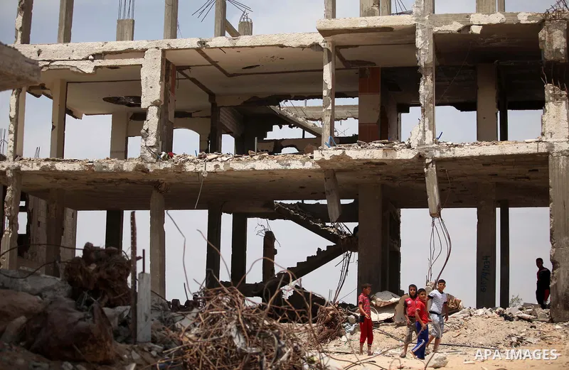 Palestinian children play on the rubble of houses which were destroyed during the 50-day war between Israel and Hamas militants in the summer of 2014, in the Al-Shaaf neighbourhood, on June 06, 2015. Qatar's ambassador M...
