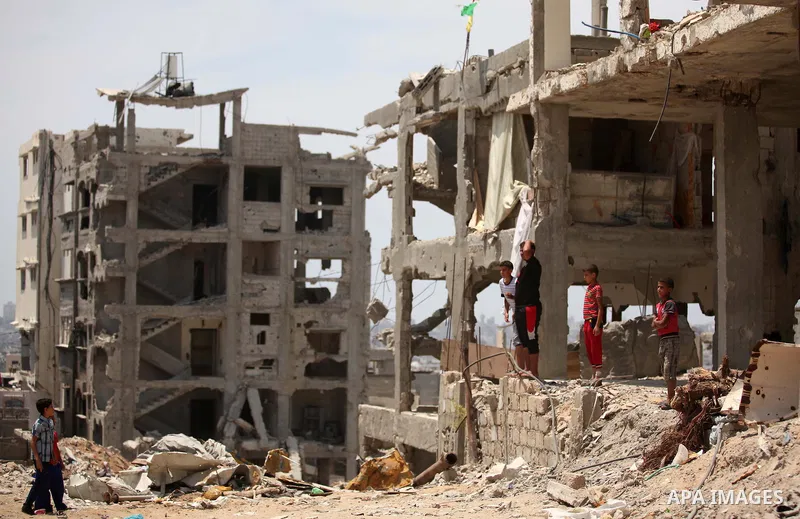 Palestinian children play on the rubble of houses which were destroyed during the 50-day war between Israel and Hamas militants in the summer of 2014, in the Al-Shaaf neighbourhood, on June 06, 2015. Qatar's ambassador M...