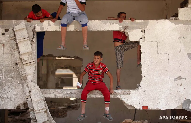 Palestinian children play on the rubble of houses which were destroyed during the 50-day war between Israel and Hamas militants in the summer of 2014, in the Al-Shaaf neighbourhood, on June 06, 2015. Qatar's ambassador M...