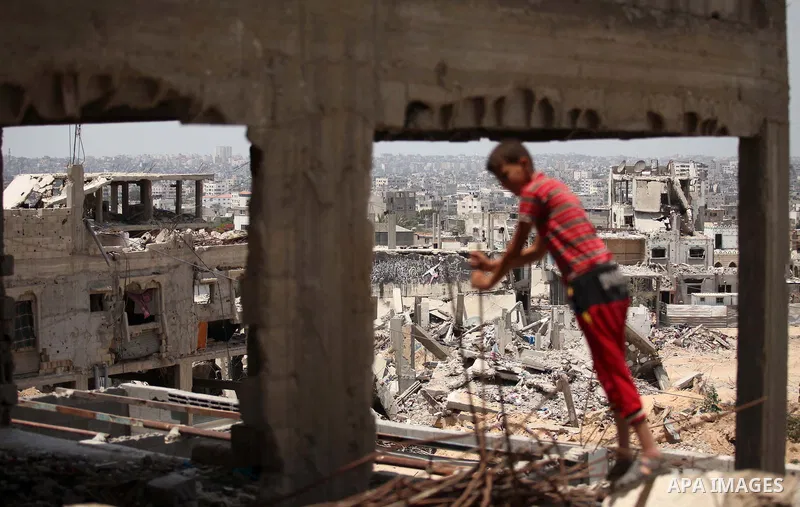 Palestinian children play on the rubble of houses which were destroyed during the 50-day war between Israel and Hamas militants in the summer of 2014, in the Al-Shaaf neighbourhood, on June 06, 2015. Qatar's ambassador M...