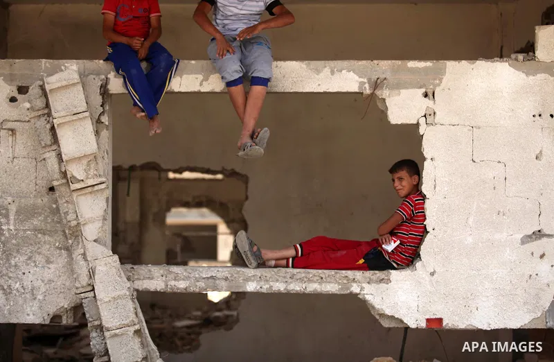 Palestinian children play on the rubble of houses which were destroyed during the 50-day war between Israel and Hamas militants in the summer of 2014, in the Al-Shaaf neighbourhood, on June 06, 2015. Qatar's ambassador M...