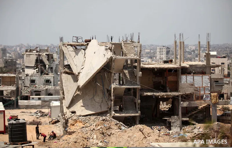 Palestinians sit on the rubble of houses which were destroyed during the 50-day war between Israel and Hamas militants in the summer of 2014, in the Al-Shaaf neighbourhood, on June 06, 2015. Qatar's ambassador Mohammed a...