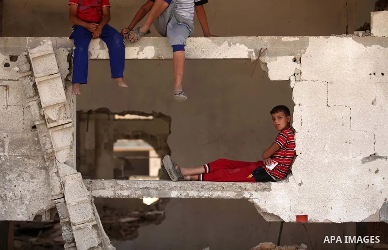 Palestinian children play on the rubble of houses which were destroyed during the 50-day war between Israel and Hamas militants in the summer of 2014, in the Al-Shaaf neighbourhood, on June 06, 2015. Qatar's ambassador M...