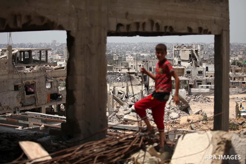 Palestinian children play on the rubble of houses which were destroyed during the 50-day war between Israel and Hamas militants in the summer of 2014, in the Al-Shaaf neighbourhood, on June 06, 2015. Qatar's ambassador M...