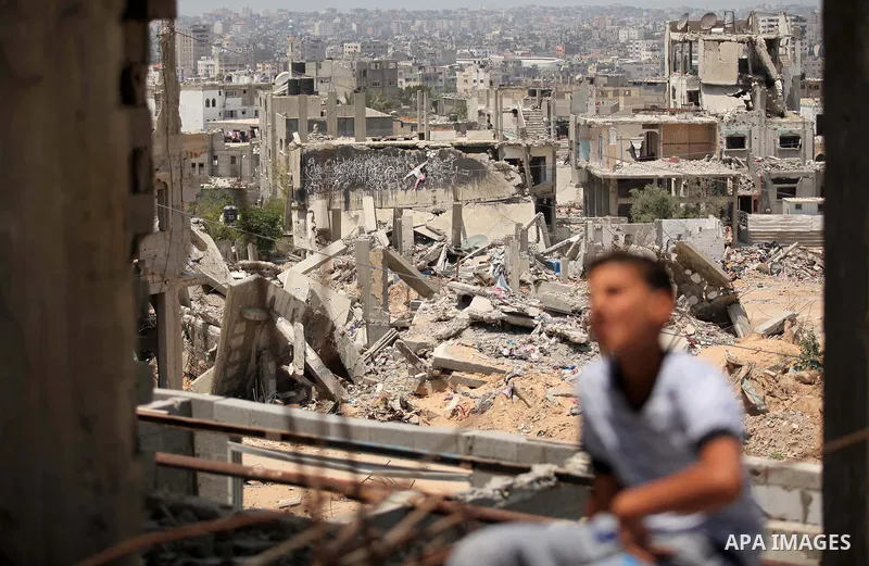 Palestinian boy sits on the rubble of houses which were destroyed during the 50-day war between Israel and Hamas militants in the summer of 2014, in the Al-Shaaf neighbourhood, on June 06, 2015. Qatar's ambassador Mohamm...