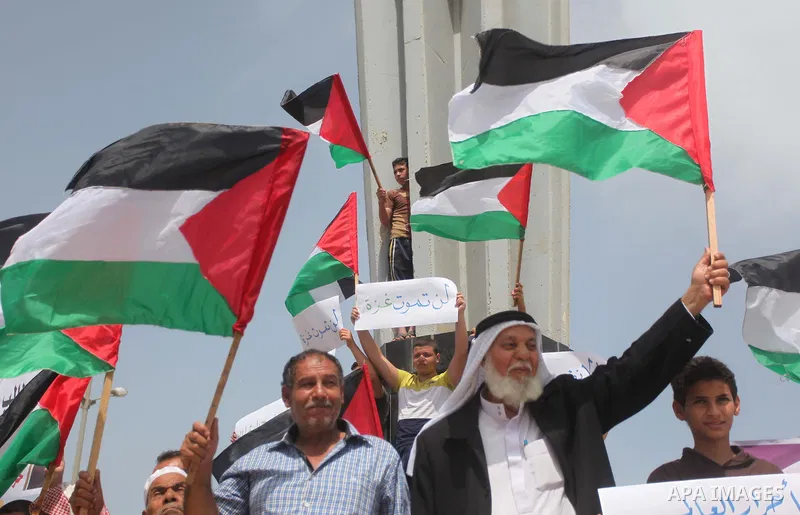 Palestinians take part in a protest demanding for the opening of a waterway, reconstruction of houses, and to break the siege at the Gaza seaport on March 07, 2015. Photo by Ashraf Amra