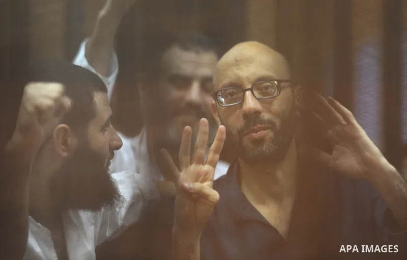 Egyptian Muslim Brotherhood Members sit at defendants cage as they attend their trial along with former president Mohamed Morsi at Cairo criminal court on June 7, 2015. Cairo criminal court considers today, Sunday a new...