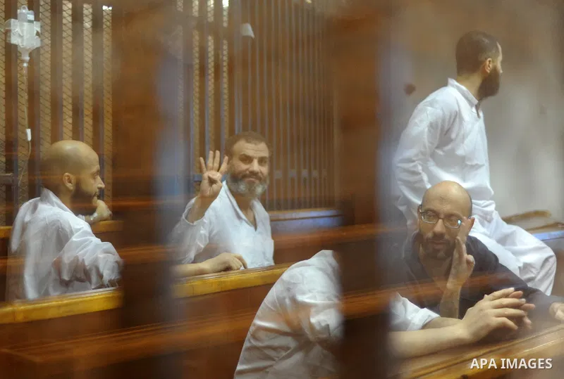 Egyptian Muslim Brotherhood Members sit at defendants cage as they attend their trial along with former president Mohamed Morsi at Cairo criminal court on June 7, 2015. Cairo criminal court considers today, Sunday a new...