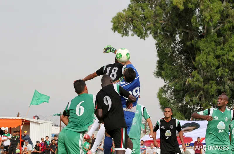Players of al-Shijaiyah club compete against players of Rafah club during the final match of a local championship, at al-Yarmouk stadium in Gaza city on June 7, 2015. Photo by Mohammed al-Dallow