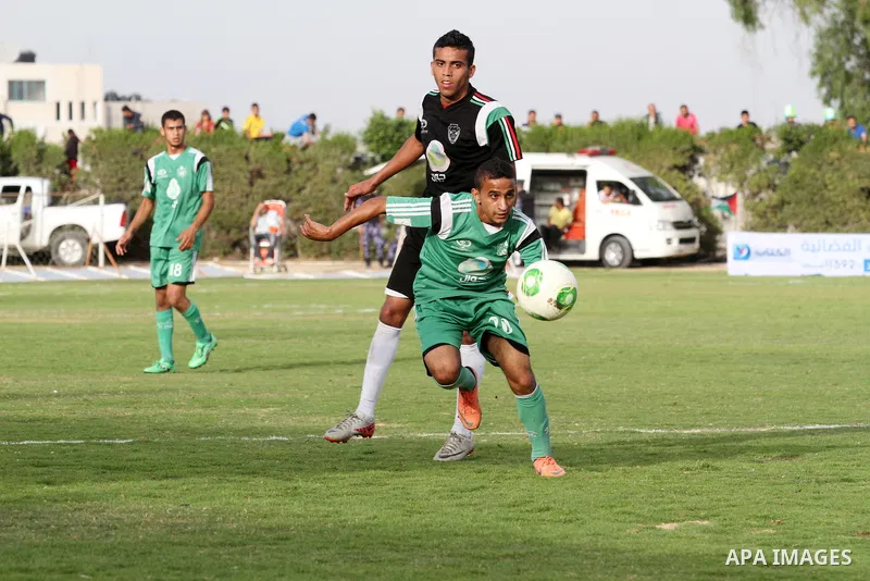 Players of al-Shijaiyah club compete against players of Rafah club during the final match of a local championship, at al-Yarmouk stadium in Gaza city on June 7, 2015. Photo by Mohammed al-Dallow