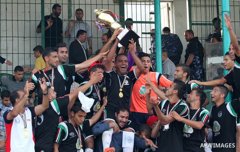 Players of al-Shijaiyah club raise the championship trophy after winning the final match against Rafah club in a local championship, at al-Yarmouk stadium in Gaza city on June 7, 2015. Photo by Mohammed al-Dallow