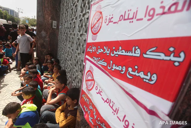 Palestinian orphans take part in a protest demanding their rights in front of Palestine Bank, in Gaza city on June 8, 2015. Photo by Ashraf Amra