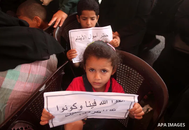 Palestinian orphans take part in a protest demanding their rights in front of Palestine Bank, in Gaza city on June 8, 2015. Photo by Ashraf Amra
