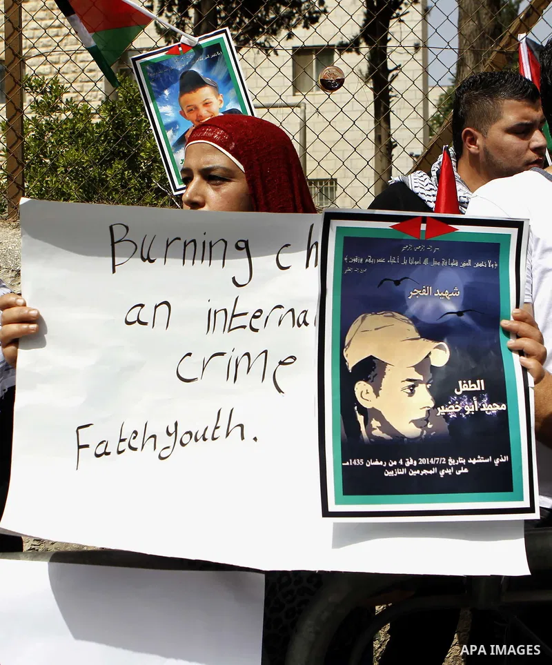 Palestinians hold placards during a demonstration in support of the family of Mohammed Abu Khder (portrait), a Palestinian teenager who was kidnapped from east Jerusalem on July 2,2014 and burned to death by Jewish extre...