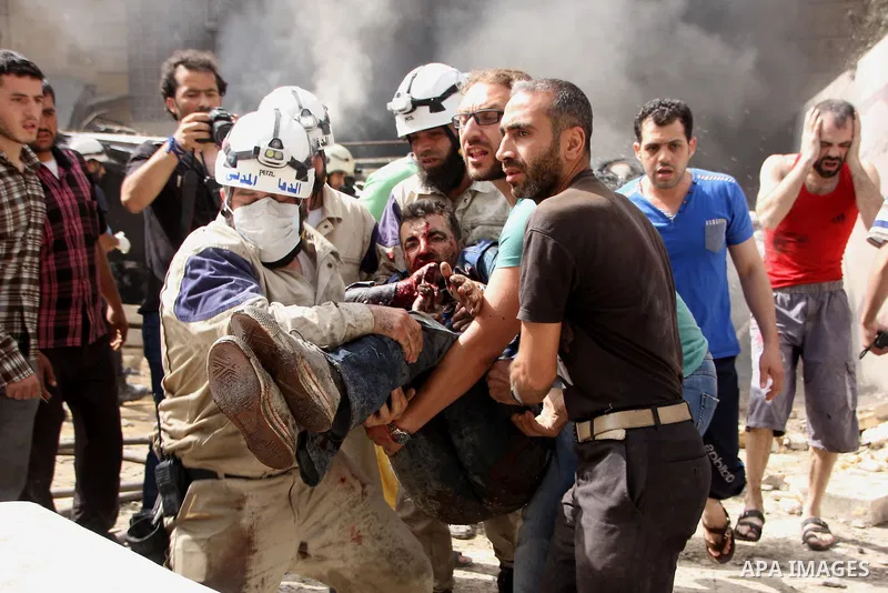 Rescue workers search carry the body of a man who was injured in a reported barrel bomb attack by Syrian government forces, at al-Ansari district in the northern Syrian city of Aleppo, June 9, 2015. At least a civilian w...