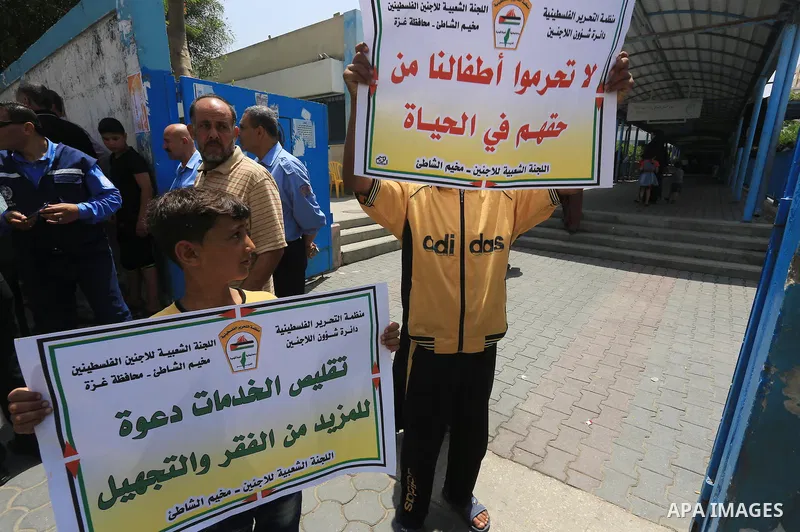 Palestinians hold banners during a protest against the UNRWA decision to reduce of the food aid in front of the headquarters United Nations Relief and Works Agency (UNRWA), in Gaza city, June 9, 2015. Photo by Mohammed A...