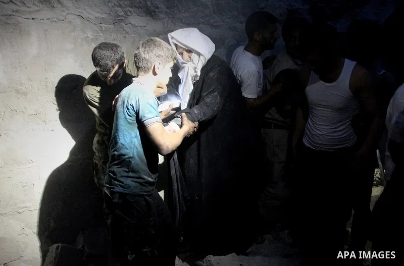 Syrian rescue workers and citizens evacuate a woman from a building after a reported barrel bomb attack by Syrian government forces at al-mayser district in the northern Syrian city of Aleppo, June 8, 2015. Photo by Amee...