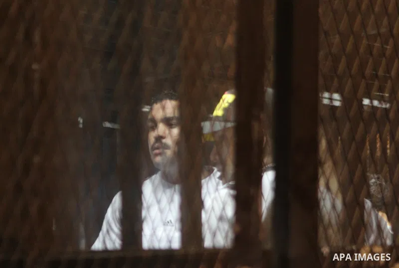 Egyptian defendants react behind bars after the verdict in their retrial over a 2012 stadium riot in the canal city of Port Said that left 74 people dead, in a court in the Egyptian capital, Cairo on June 9, 2015. The co...