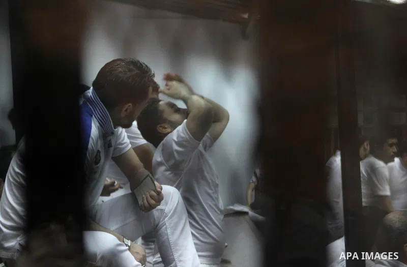Egyptian defendants react behind bars after the verdict in their retrial over a 2012 stadium riot in the canal city of Port Said that left 74 people dead, in a court in the Egyptian capital, Cairo on June 9, 2015. The co...