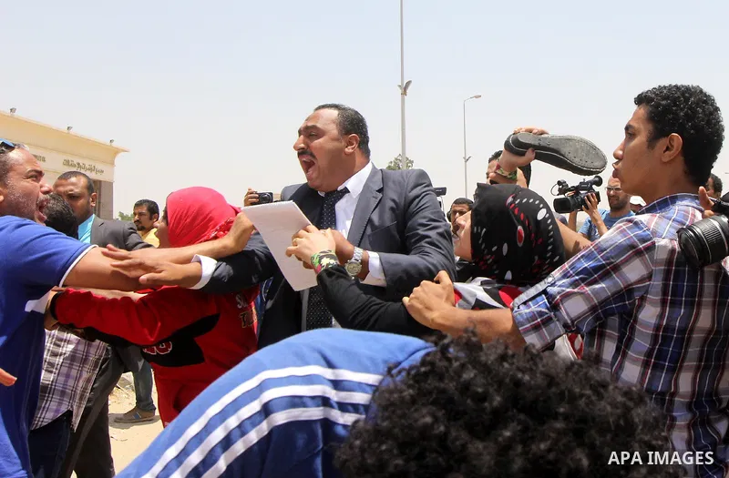 Egyptian families of the victims of a February 2012 riot in the eastern city of Port Said gather outside a court in Cairo on June 9, 2015 as they wait for the final verdict in the retrial of football fans over the riot t...