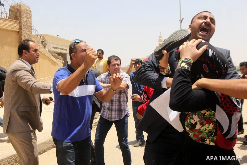 Egyptian families of the victims of a February 2012 riot in the eastern city of Port Said gather outside a court in Cairo on June 9, 2015 as they wait for the final verdict in the retrial of football fans over the riot t...