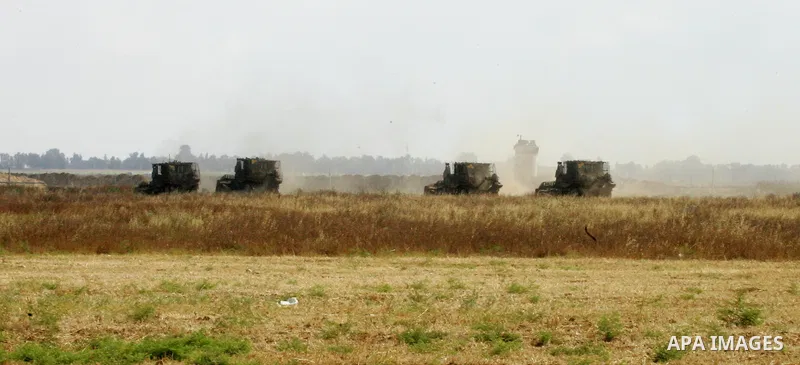 Israeli bulldozers work along a barbed wire fence that separates Khan Yunis in the southern Gaza Strip and the Israeli border, on June 10, 2015. Israel is to reopen border crossings to and from the Gaza Strip the coming...