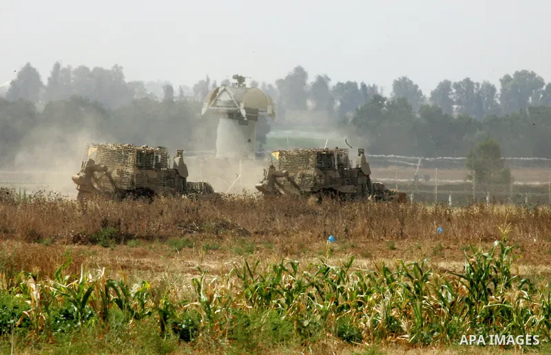 Israeli bulldozers work along a barbed wire fence that separates Khan Yunis in the southern Gaza Strip and the Israeli border, on June 10, 2015. Israel is to reopen border crossings to and from the Gaza Strip the coming...