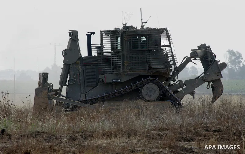 An Israeli bulldozer works along a barbed wire fence that separates Khan Yunis in the southern Gaza Strip and the Israeli border, on June 10, 2015. Israel is to reopen border crossings to and from the Gaza Strip the comi...