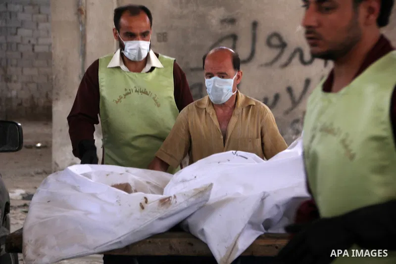 A Red Crescent worker carries a body of dead fighter loyal to Free Syrian Army on carts during an exchange of dead bodies between Free Syrian Army and Syrian Government forces, in Bustan al-Qasr district in the east of t...