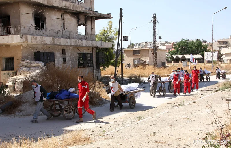 Red Crescent workers carry the bodies of dead fighters loyal to Free Syrian Army on carts during an exchange of dead bodies between Free Syrian Army and Syrian Government forces, in Bustan al-Qasr district in the east of...