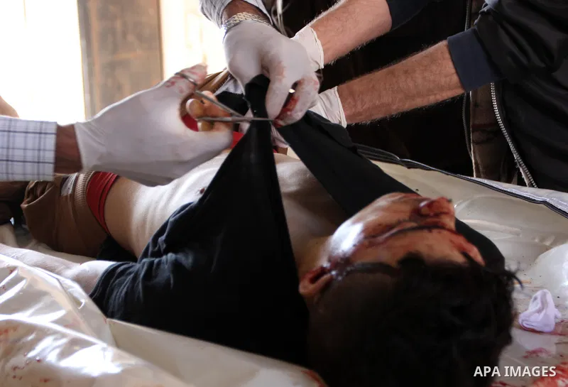 Syrian medics inspect the body of an unidentified killed man found in Saliheen neighborhood, at a hospital morgue in al-Sukari district in the east of the northern Syrian city of Aleppo on June 11, 2015. Photo by Ameer a...