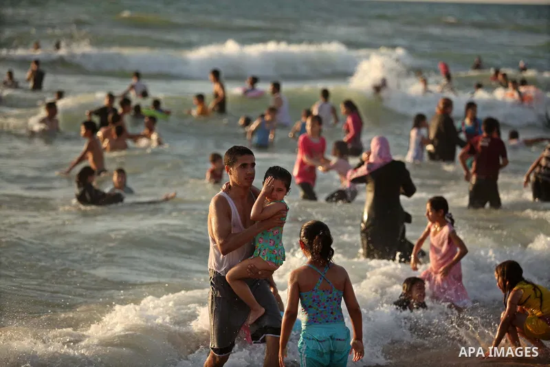 Palestinians enjoy a day at the beach of the Mediterranean Sea on the coast of Gaza City, on June 12, 2015. Photo by Ashraf Amra
