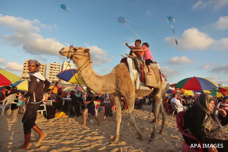 Palestinians enjoy a day at the beach of the Mediterranean Sea on the coast of Gaza City, on June 12, 2015. Photo by Ashraf Amra