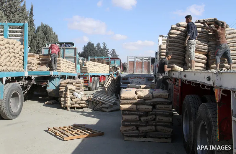 Palestinian workers offload a truck loaded with cement after it entered from Egypt through the Rafah border crossing in southern Gaza Strip, on June 13, 2015. Egyptian authorities for the first time since the expulsion o...