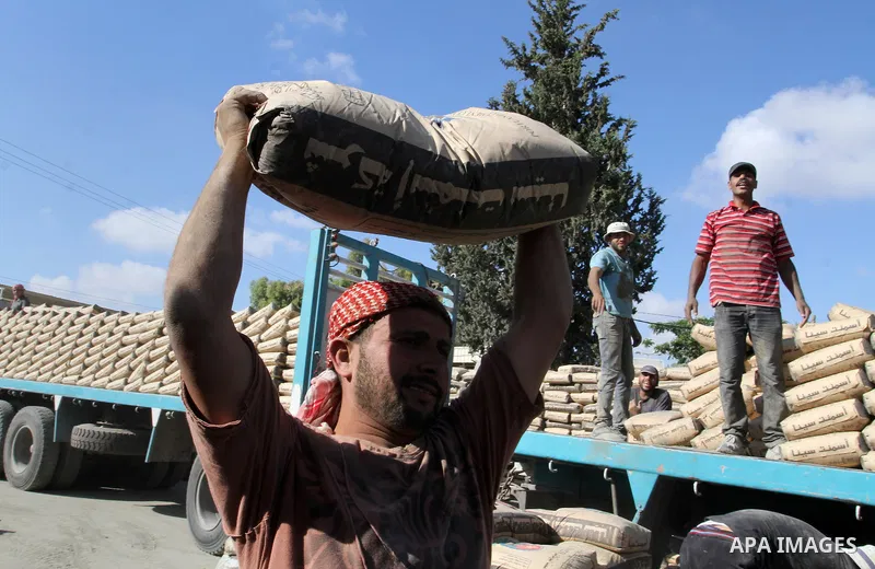 Palestinian workers offload a truck loaded with cement after it entered from Egypt through the Rafah border crossing in southern Gaza Strip, on June 13, 2015. Egyptian authorities for the first time since the expulsion o...