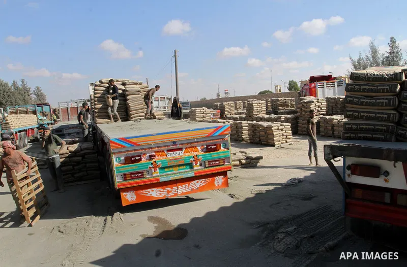 Palestinian workers offload a truck loaded with cement after it entered from Egypt through the Rafah border crossing in southern Gaza Strip, on June 13, 2015. Egyptian authorities for the first time since the expulsion o...