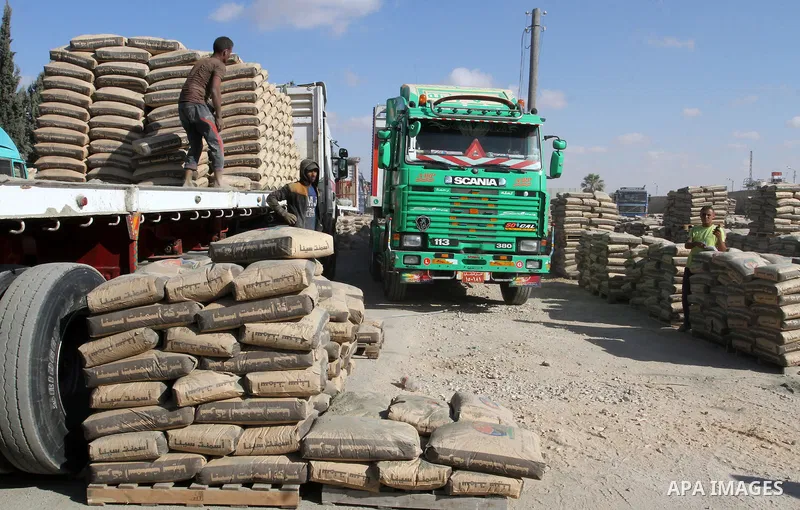 Palestinian workers offload a truck loaded with cement after it entered from Egypt through the Rafah border crossing in southern Gaza Strip, on June 13, 2015. Egyptian authorities for the first time since the expulsion o...