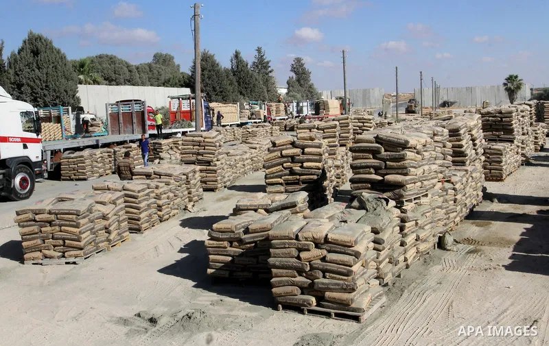 Palestinian workers offload a truck loaded with cement after it entered from Egypt through the Rafah border crossing in southern Gaza Strip, on June 13, 2015. Egyptian authorities for the first time since the expulsion o...