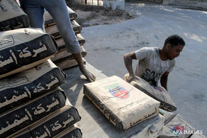 Palestinian workers offload a truck loaded with cement after it entered from Egypt through the Rafah border crossing in southern Gaza Strip, on June 13, 2015. Egyptian authorities for the first time since the expulsion o...