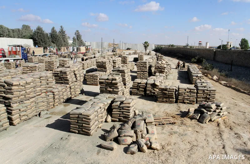 Palestinian workers offload a truck loaded with cement after it entered from Egypt through the Rafah border crossing in southern Gaza Strip, on June 13, 2015. Egyptian authorities for the first time since the expulsion o...